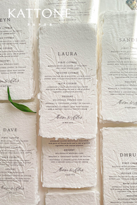 These embossed handmade paper wedding menus embody the essence of refined elegance and timeless artistry. Each piece is crafted from 100% cotton rag paper, known for its organic texture and signature deckled edges that add an artisanal, heirloom feel. The design features delicate blind embossing of botanical motifs, adding soft dimension and sophistication, while luxurious typography in classic ink beautifully contrasts the natural paper’s tactile surface.