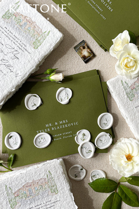 Finish your stationery with a timeless, bespoke touch using these handcrafted wax seals, designed to elevate envelopes and paper goods with subtle elegance. Each seal is individually poured and stamped, showcasing a clean ivory wax base accented with a personalized monogram and delicate botanical details. Perfect for wedding invitations, save the dates, or luxury correspondence, these wax seals add depth, texture, and heirloom character to every piece.