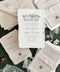 Luxury handmade cotton paper wedding invitation with deckled edges and venue illustration, styled with blush inserts, lace ribbon, wax seals and neutral envelopes on deep green background.
