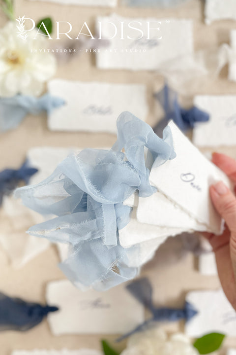 Add soft, romantic detailing to your tablescape with our silk ribbon handmade paper place cards, crafted from premium cotton rag paper and finished with naturally torn deckled edges. Each name tag is threaded with airy, hand-dyed silk ribbon and printed in elegant calligraphy, creating a luxurious fine-art look for weddings, rehearsal dinners, and intimate celebrations. These artisan-crafted cards bring movement, texture, and timeless beauty to your event design.