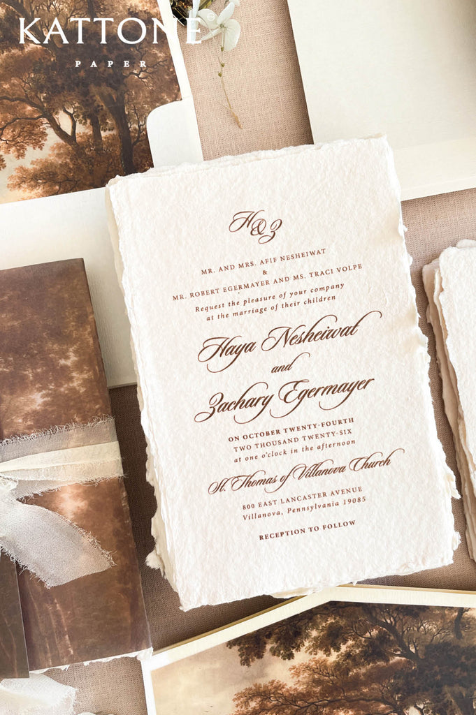 Elegant handmade paper wedding invitation with deckled edges featuring refined calligraphy typography and timeless romantic styling.
