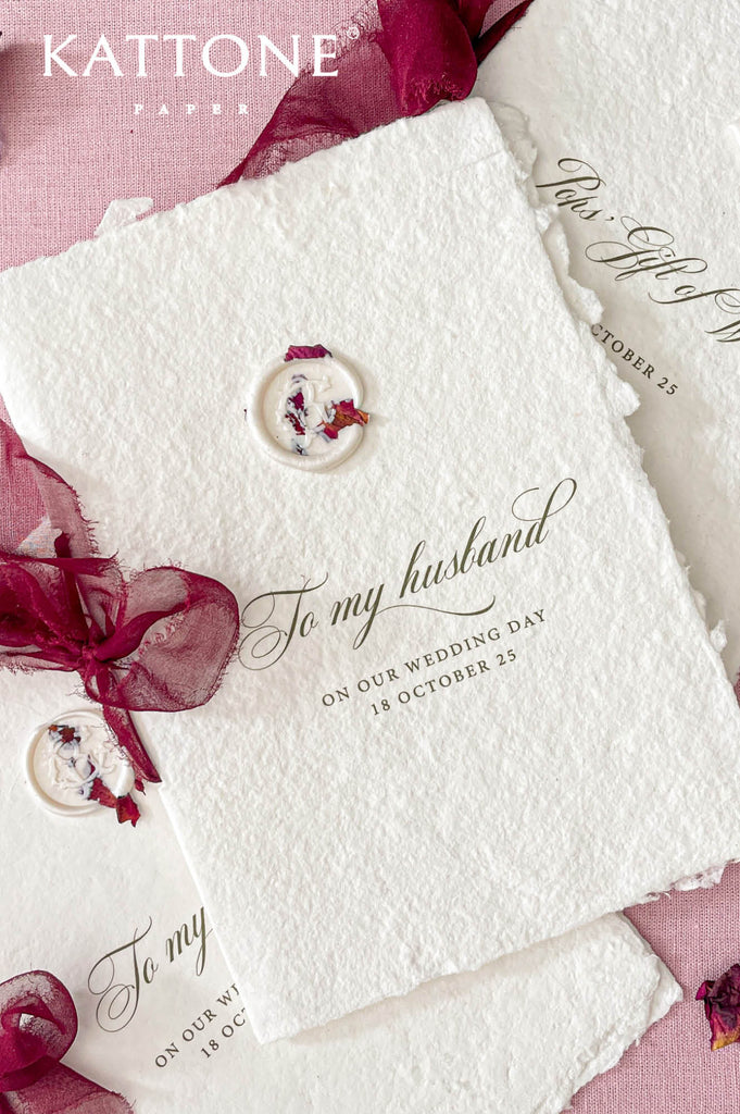 Minimalist wedding vow book printed on textured handmade paper with wax seal and soft burgundy ribbon