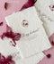 Handmade paper wedding vow booklet with deckled edges, elegant calligraphy text, and wax seal on blush background