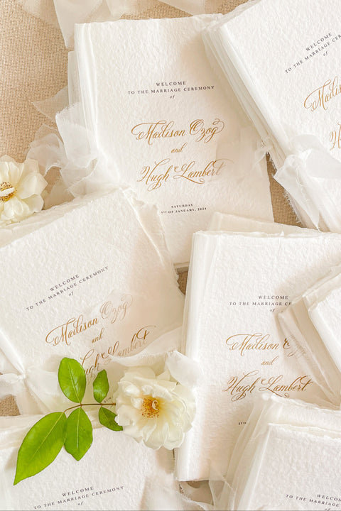 A beautifully handcrafted wedding program made from premium cotton paper, designed to elevate your ceremony with soft texture, timeless script, and a romantic ribbon finish. Each program is thoughtfully created to introduce your guests to the most meaningful moments of your day, blending fine-art aesthetics with the warmth of handmade craftsmanship. Ideal for classic, garden, or luxury weddings, it delivers a refined first impression that sets the tone for a heartfelt celebration.
