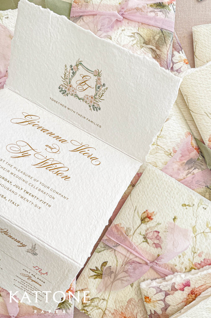Elegant concertina handmade paper wedding invitation with deckled edges designed in a fold-out format featuring refined typography and romantic floral artwork.