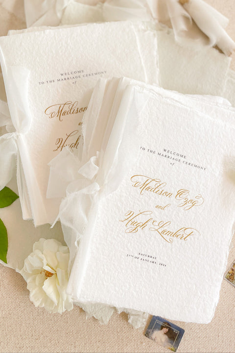 A beautifully handcrafted wedding program made from premium cotton paper, designed to elevate your ceremony with soft texture, timeless script, and a romantic ribbon finish. Each program is thoughtfully created to introduce your guests to the most meaningful moments of your day, blending fine-art aesthetics with the warmth of handmade craftsmanship. Ideal for classic, garden, or luxury weddings, it delivers a refined first impression that sets the tone for a heartfelt celebration.