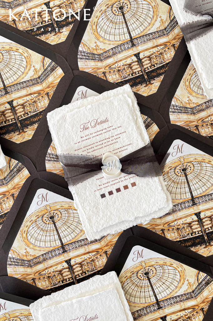 Premium handmade wedding invitation suite with custom venue artwork, deckled edge cotton paper, rich brown envelopes, black ribbon accents, and elegant monochromatic styling for formal weddings.
