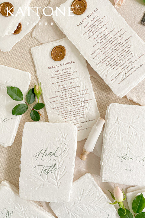 Discover refined craftsmanship with our embossed handmade wedding menus, designed to elevate your reception with timeless luxury. Each piece is pressed onto cotton handmade paper featuring delicate botanical embossing and finished with a wax seal for a touch of old-world elegance. Perfect for fine-art, romantic, or luxury weddings, these menus combine artisanal texture with understated sophistication.