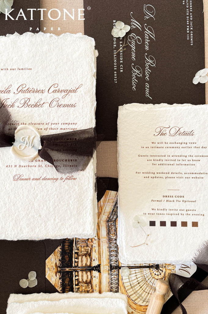 Elegant handmade cotton paper wedding invitation with deckled edges featuring refined script typography, black chiffon ribbon wrap, and personalized ivory wax seal.