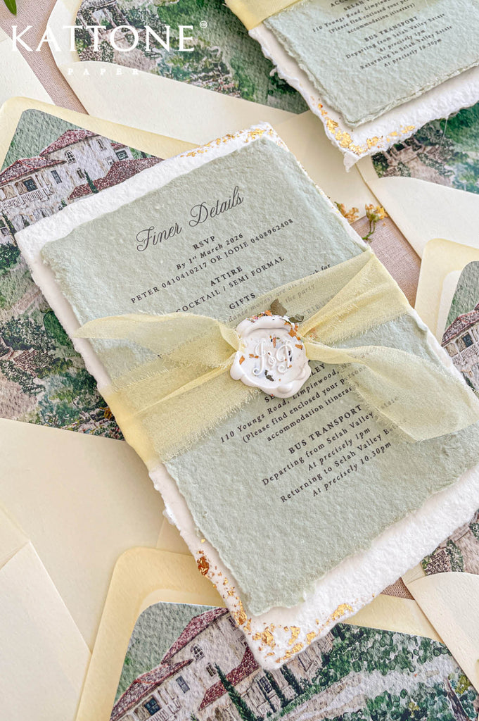 Close up of handmade cotton paper invitation highlighting textured deckled edges, gold leaf details and refined typography.