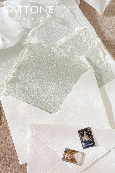 Close-up of handmade paper envelope showing soft texture, deckled edges, and refined liner detail inside.