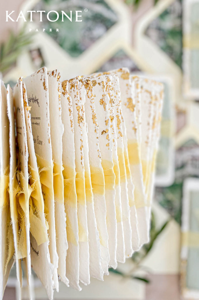 Handmade cotton paper with visible fibers and organically torn deckled edges emphasizing artisanal craftsmanship.