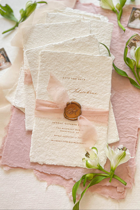Announce your wedding day with effortless elegance through our handmade paper Save the Date cards, a perfect blend of romance and artisanal craftsmanship. Printed on luxury 100% cotton paper with soft deckled edges, each piece is wrapped in a delicate blush silk ribbon and finished with a hand-pressed wax seal, creating a timeless keepsake that captures the essence of fine-art stationery.
