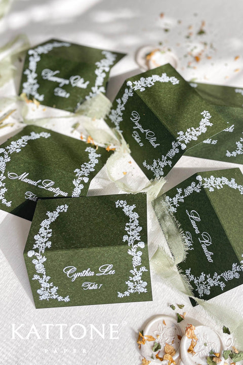 Elevate your tablescape with our elegant forest green place cards featuring delicate white floral illustrations and refined handwritten-style lettering. Crafted on premium cardstock, each folded card brings depth, contrast, and timeless sophistication to your wedding or special event. Perfect for modern, botanical, and luxury themes, these place cards add a polished and cohesive finishing touch to guest seating.