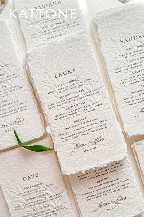 These embossed handmade paper wedding menus embody the essence of refined elegance and timeless artistry. Each piece is crafted from 100% cotton rag paper, known for its organic texture and signature deckled edges that add an artisanal, heirloom feel. The design features delicate blind embossing of botanical motifs, adding soft dimension and sophistication, while luxurious typography in classic ink beautifully contrasts the natural paper’s tactile surface.