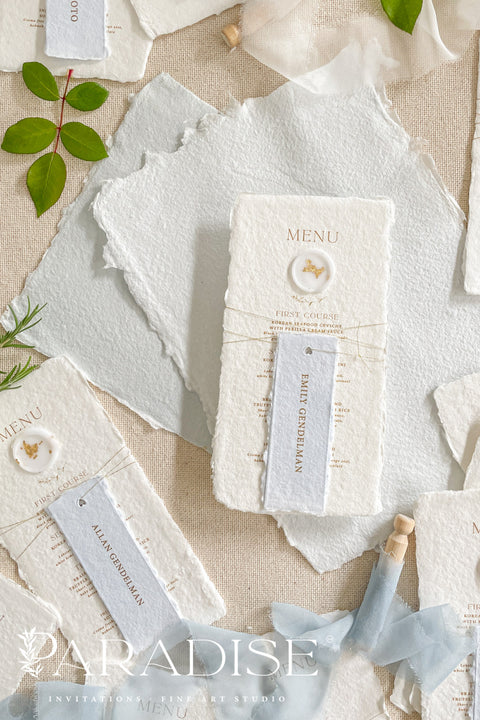 These handmade paper wedding menus are the embodiment of fine art elegance - timeless, refined, and delicately handcrafted. Made from 100% cotton rag paper, each menu showcases naturally deckled edges and a soft, tactile surface that enhances its artisanal charm. The design features gold-printed text, a minimalist layout, and a custom wax seal with gold leaf detailing, paired with a personalized name tag for each guest - seamlessly combining beauty and function.