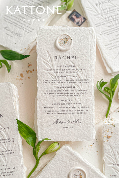 These embossed handmade paper wedding menus embody the essence of refined elegance and timeless artistry. Each piece is crafted from 100% cotton rag paper, known for its organic texture and signature deckled edges that add an artisanal, heirloom feel. The design features delicate blind embossing of botanical motifs, adding soft dimension and sophistication, while luxurious typography in classic ink beautifully contrasts the natural paper’s tactile surface.