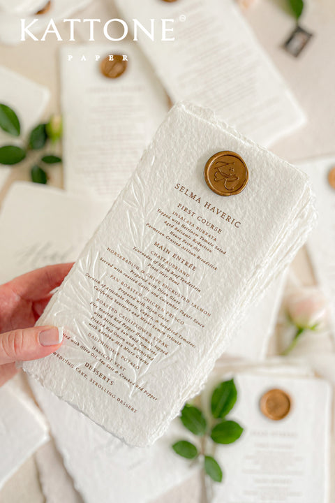 Discover refined craftsmanship with our embossed handmade wedding menus, designed to elevate your reception with timeless luxury. Each piece is pressed onto cotton handmade paper featuring delicate botanical embossing and finished with a wax seal for a touch of old-world elegance. Perfect for fine-art, romantic, or luxury weddings, these menus combine artisanal texture with understated sophistication.