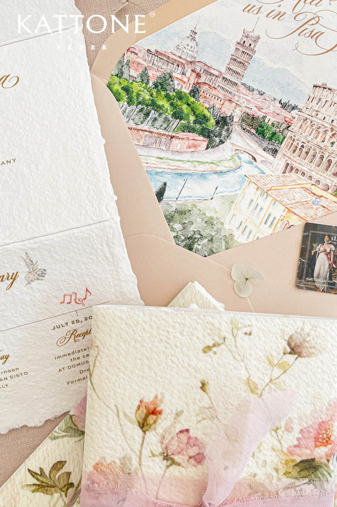 Soft translucent vellum wrap layered over tri-fold handmade paper wedding invitations, showcasing floral artwork beneath for an elevated presentation.