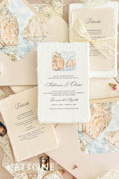 Overhead flat lay of an elegant Sicily-inspired wedding invitation suite featuring ivory handmade paper invitations with coastal watercolor illustrations, champagne envelopes with matching Mediterranean cliff envelope liners, and warm beige handmade paper wedding details cards tied with delicate ivory lace bows. The stationery is arranged on natural linen with soft romantic lace accents.