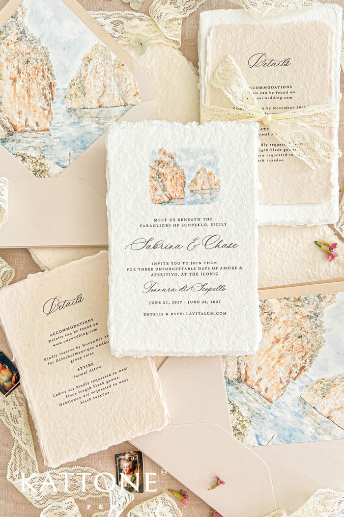 Overhead flat lay of an elegant Sicily-inspired wedding invitation suite featuring ivory handmade paper invitations with coastal watercolor illustrations, champagne envelopes with matching Mediterranean cliff envelope liners, and warm beige handmade paper wedding details cards tied with delicate ivory lace bows. The stationery is arranged on natural linen with soft romantic lace accents.