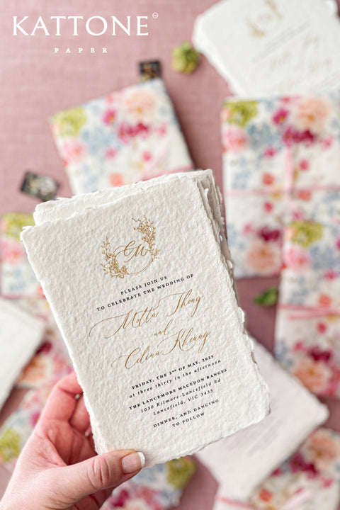 Announce your special day with a touch of modern romance with these exquisite wedding invitations. Perfect for a summer wedding, each suite features a delicate floral design printed on a translucent vellum jacket. Your personal custom monogram adds an elegant and personal touch, and the invitations are printed on luxurious handmade paper, creating a beautifully layered and bespoke stationery set.