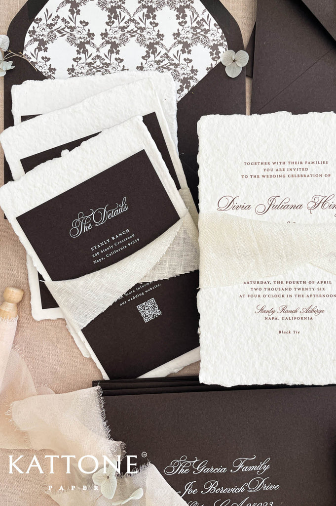 Close up of handmade cotton paper invitation highlighting textured deckled edges, soft chiffon ribbon and refined typography.