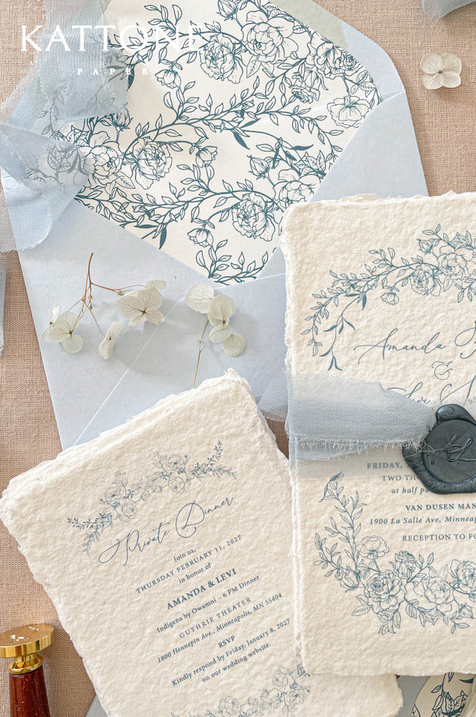 Soft blue envelopes with coordinating floral liners create a cohesive and elevated wedding stationery presentation.
