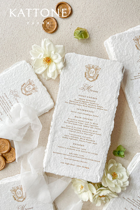 These handmade paper wedding menus with a custom monogram bring timeless elegance and refined craftsmanship to your wedding tablescape. Meticulously crafted from 100% cotton rag paper, each menu features natural deckled edges and a soft, luxurious texture that exudes artisanal charm. The custom monogram or crest - printed in elegant gold foil - adds a personal and regal touch, making every detail feel truly bespoke.