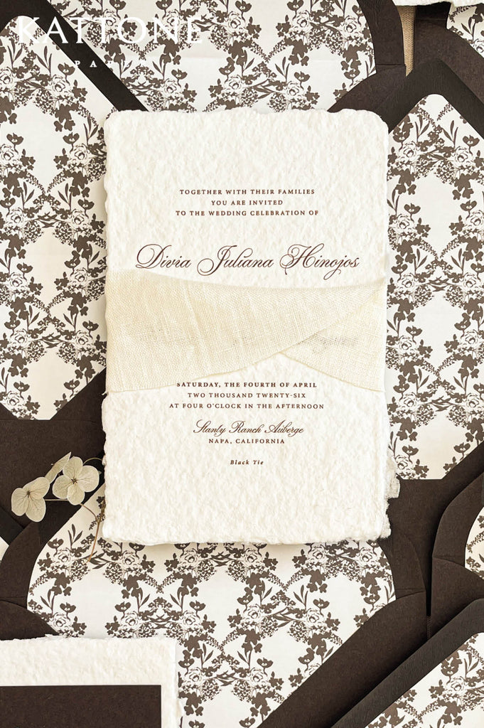 Ivory chiffon ribbon wrapped around handmade wedding invitation adding soft movement and romantic texture.