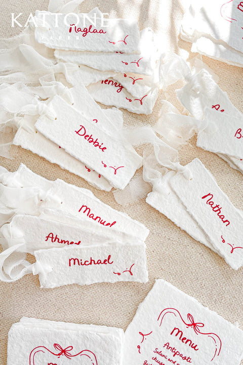 Bring playful charm to your table setting with our handmade paper place cards featuring whimsical red doodles. Each card is crafted from premium deckled-edge cotton paper and finished with delightful hand-drawn accents that add personality and joy to your celebration. Perfect for weddings, parties, kids’ events, or any occasion that calls for a touch of creativity.