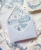 Light blue wedding envelopes with hand-drawn venue envelope liners styled with handmade paper and fine art stationery details.