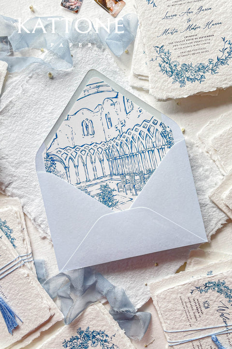 Light blue wedding envelopes with hand-drawn venue envelope liners styled with handmade paper and fine art stationery details.
