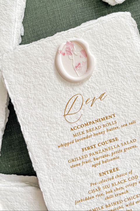 Close-up of handmade cotton paper wedding menu featuring delicate wax seal accent and refined lettering.