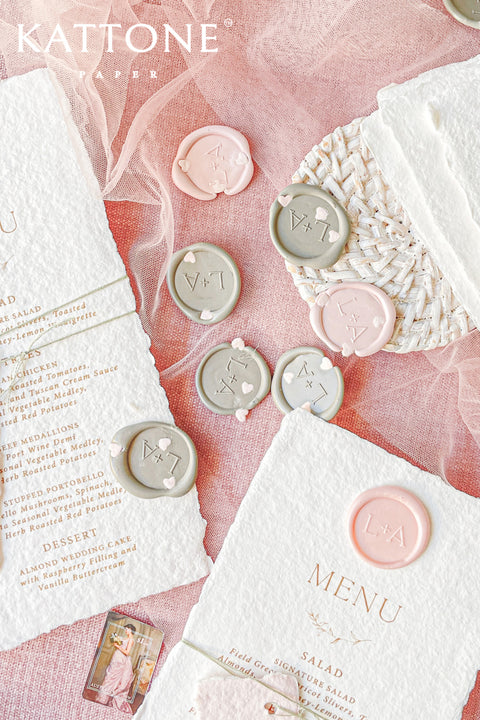 These handmade paper wedding menus capture the essence of romance and artisanal beauty. Crafted from 100% cotton rag paper, each menu features deckled edges, a luxurious tactile finish, and a timeless aesthetic that perfectly complements any elegant tablescape. The menus are adorned with a personalized wax seal and a custom name tag, adding a thoughtful, bespoke touch that enhances your guests’ dining experience.