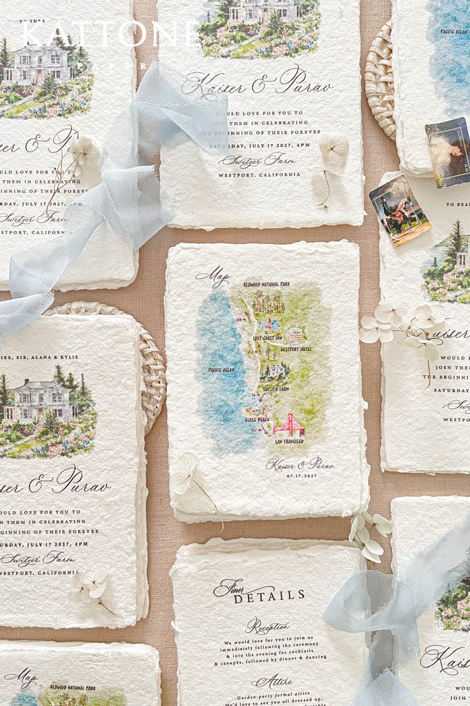 Custom handmade paper wedding map insert with watercolor illustrated landmarks, coastal scenery, and wedding destination details designed for guest travel guidance.