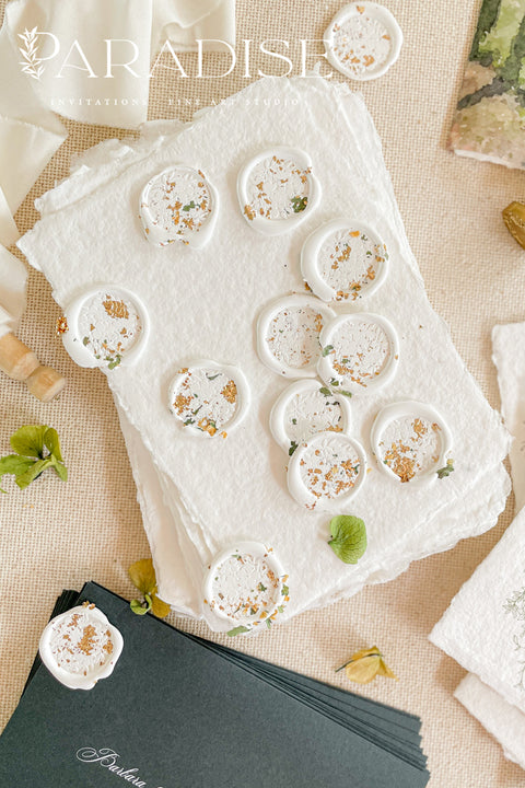 Elevate your wedding stationery with these handcrafted wax seals, designed to add a timeless, artisanal finishing touch to invitations, envelopes, and day-of details. Each seal is individually poured in a soft ivory tone and delicately embellished with botanical accents, creating an organic, romantic look that feels both luxurious and intentional. Perfect for couples who appreciate fine paper goods and thoughtful details, these wax seals bring warmth, texture, and heirloom charm to every celebration.