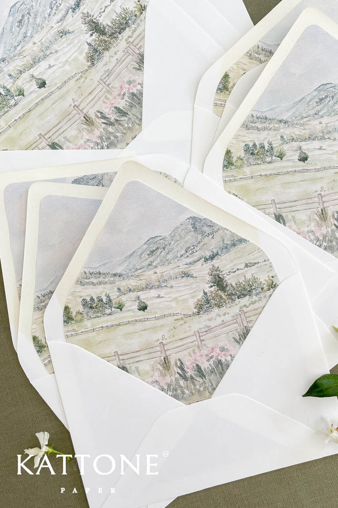 Close up of envelope liner featuring soft watercolor landscape artwork and painterly detail