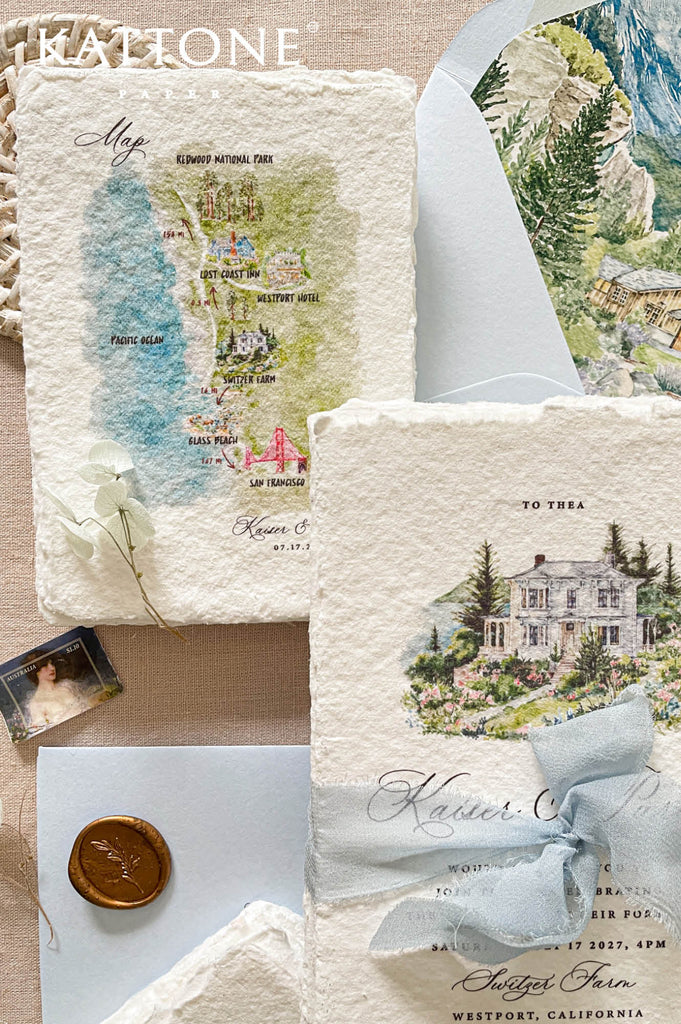 Custom handmade paper wedding map insert with watercolor illustrated landmarks, coastal scenery, and wedding destination details designed for guest travel guidance.