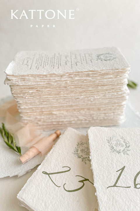 Watercolor greenery and handmade deckle-edge cotton paper create a naturally elegant table number design that brings soft, organic beauty to your wedding décor. The delicate botanical wreath and refined numeral style add a fine-art, timeless touch, making each card feel both romantic and elevated. Perfect for garden weddings, outdoor celebrations, and nature-inspired themes, this design blends airy watercolor tones with luxurious craftsmanship.