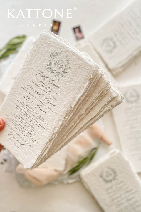 These handmade paper wedding menus capture the essence of timeless romance and artisanal elegance. Crafted from 100% cotton rag paper, each menu features naturally deckled edges and a rich, tactile texture that reflects the beauty of handcrafted design. The refined layout is elevated by a custom watercolor monogram framed in soft botanical details, bringing a delicate and personal touch to your wedding table.