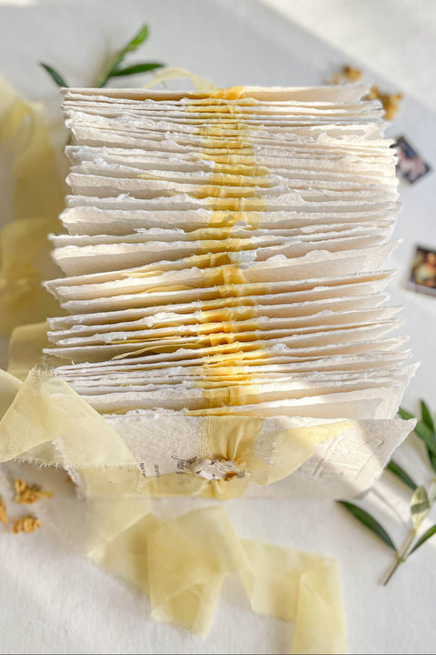 Announce your wedding with refined elegance through our embossed handmade paper Save the Date cards, crafted on luxury 100% cotton handmade paper with soft deckled edges. The embossed impression adds texture and sophistication, while each card is wrapped in a buttery yellow silk ribbon and sealed with a hand-pressed wax seal, creating a timeless and romantic presentation.