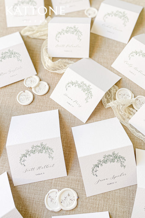 Elevate your wedding seating display with our place cards, designed on premium textured cardstock and adorned with a delicate greenery arch illustration. Their timeless botanical style blends perfectly with garden weddings, fine-art celebrations, and romantic outdoor events. These folded cards stand beautifully on tables, adding elegance, clarity, and natural charm to every setting.