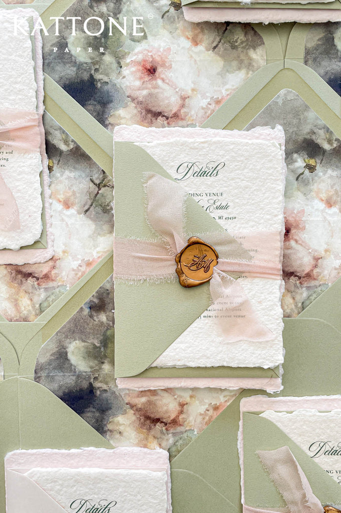 Elegant blush handmade paper wedding invitation with deckled edges featuring refined calligraphy typography and soft romantic styling.