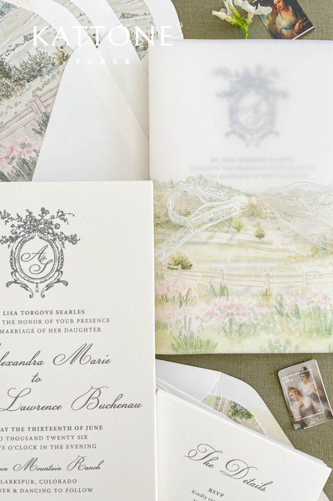 Close up of vellum wrap wedding invitation showing translucent overlay and watercolor scenery.
