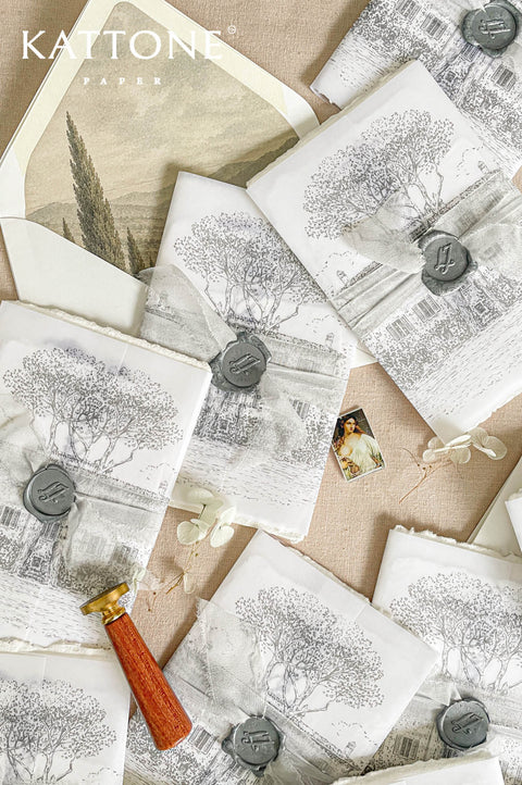 Soft translucent vellum wrap layered over handmade paper invitation with personalized wax seal for a romantic and elevated presentation.