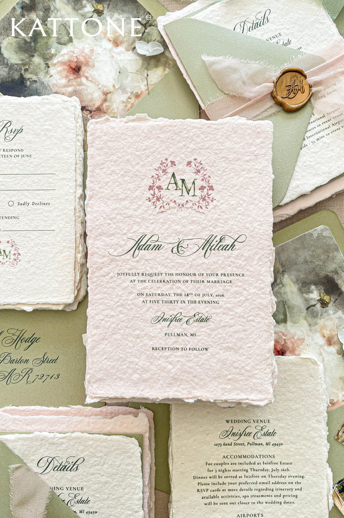 Luxury colored handmade paper wedding invitation suite featuring blush pink deckled edge cotton paper, floral monogram artwork, sage green typography, and watercolor floral liners for romantic wedding stationery.
