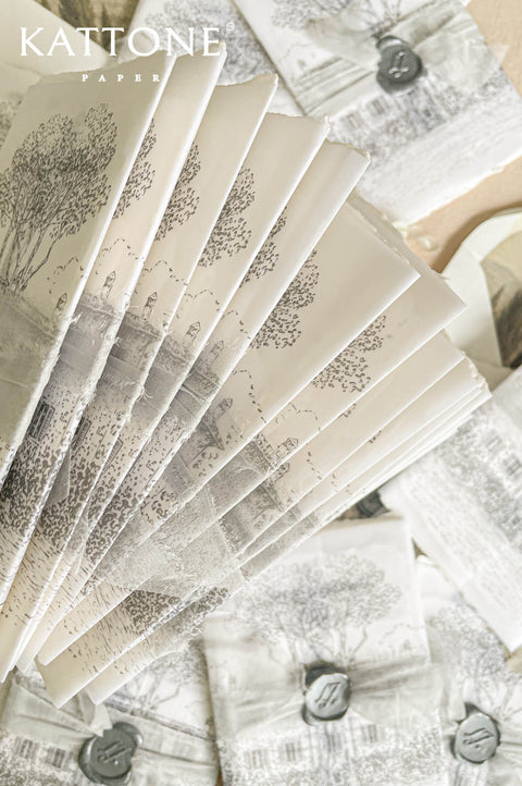 Soft translucent vellum wrap layered over handmade paper invitation with personalized wax seal for a romantic and elevated presentation.