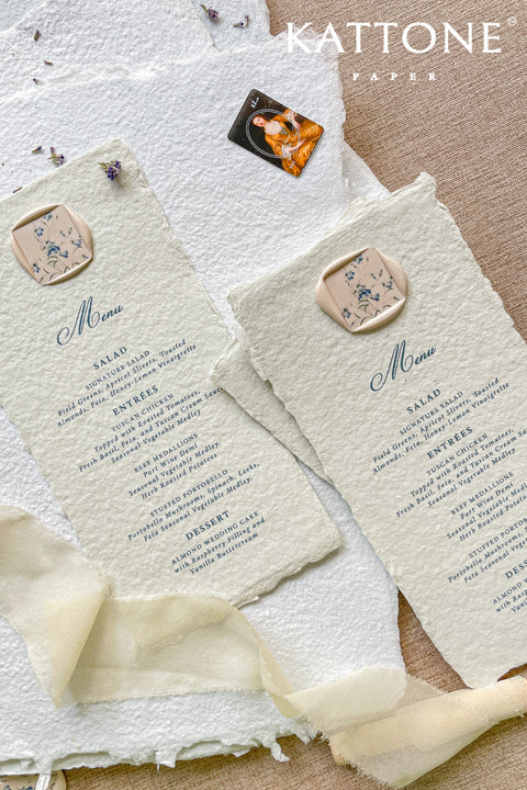 Infuse your reception with timeless artistry through our handmade paper wedding menus, featuring deckled edges, elegant typography, and floral wax seals. Each piece is crafted from soft cotton paper, offering a textured, organic finish that beautifully complements fine-art, garden, or destination weddings. Designed for couples who adore romantic, handcrafted details, these menus transform every place setting into an exquisite statement of elegance.