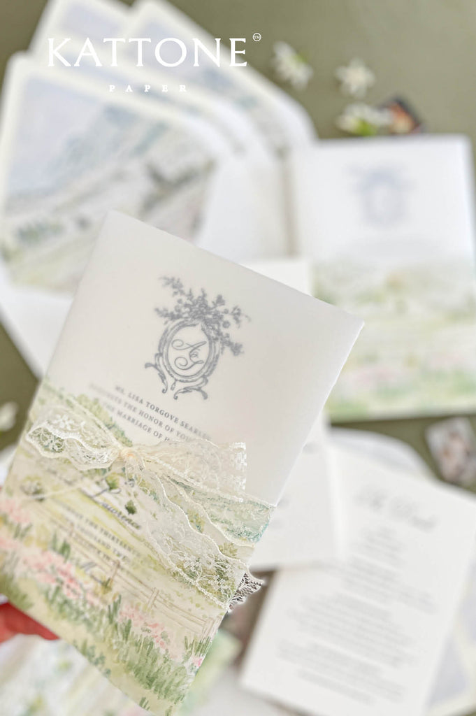 Close up of vellum wrap wedding invitation showing translucent overlay and watercolor scenery.